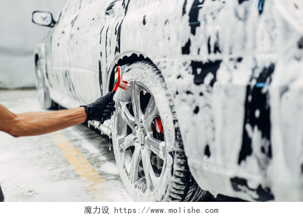 洗车店的服务洗车服务, 汽车泡沫, 侧视图。汽车细节, 用刷子清洗车轮